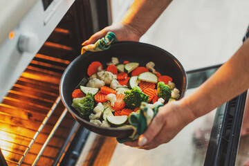Woman cooking vegetables on pan