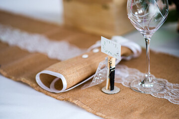 Wedding decoration mane tag from paper label wooden pin painted as bride and groom. Fine detail of a wedding table which is a great idea for wedding decorations.