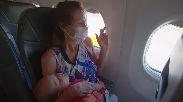 Fear of flight by plane. The passenger woman with baby sits nervously on the plane.