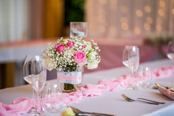 Detail of flowers on a wedding table which is ready for the guests and bride with the groom.