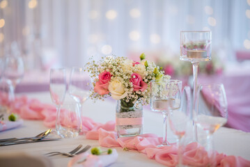 Detail of flowers on a wedding table which is ready for the guests and bride with the groom.