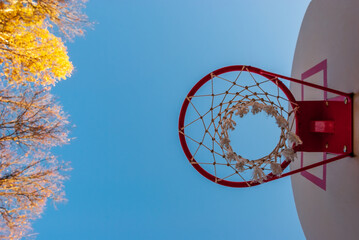 A basketball ring photographed from below against a blue sky.