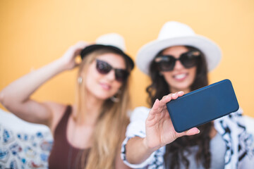 Beautiful female tourists exploring city and taking selfie