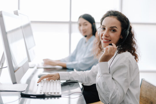 secretary operator wears a headset and microphone for consultant assistance support, the call center staff providing advice and assistance customers in smiling and happy manner while looking at camera