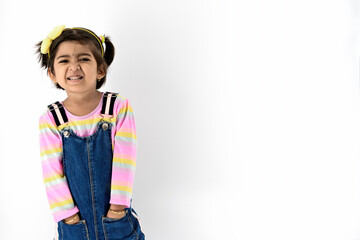 Laughing cute girl portrait with denim cloths and pony tail at home Studio. Little child smiling and looking at up with white background studio shot