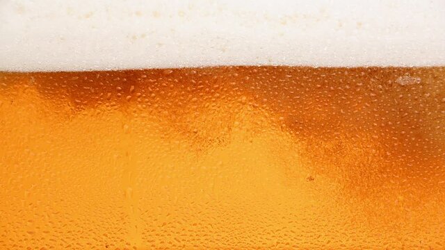 Close up background of beer with bubbles in glass
