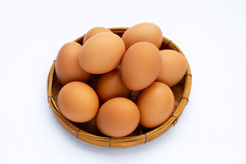 Fresh eggs in bamboo basket on white background.