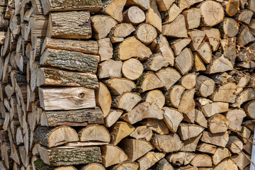 Background of hewed smooth wooden logs. Cut wood texture. Pile of chopped fire wood prepared for...