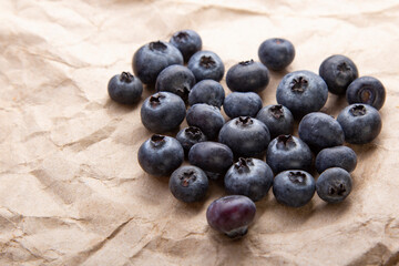 heap ripe sweet blueberries on rustic paper top view
