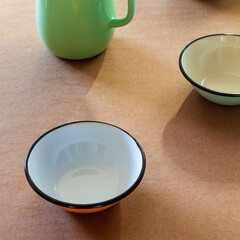 Empty enamel bowls on rustic table. Retro kitchenware utensils.