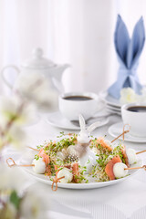 Appetizer quail egg stuffed with alfalfa sprouts with a slice of salmon, on a wooden skewer. Buffet...