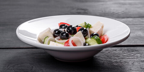 Fresh delicious Greek salad with tomato, cucumber, onions and olives with olive oil