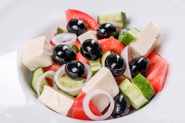 Fresh delicious Greek salad with tomato, cucumber, onions and olives with olive oil