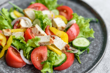 Fresh delicious salad with chicken, tomato, cucumber, onions and greens with olive oil
