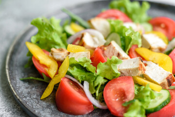 Fresh delicious salad with chicken, tomato, cucumber, onions and greens with olive oil