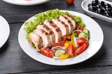 Fresh delicious salad with chicken, tomato, cucumber, onions and greens with olive oil