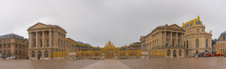 Fototapeta na wymiar Versailles, France - 19 05 2021: Castle of Versailles. View of the Honor Grid and facade of the Castle of Versailles from the Weapons Square