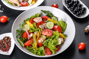 Fresh delicious salad with chicken, tomato, cucumber, onions and greens with olive oil