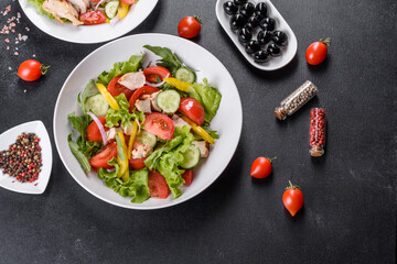 Fresh delicious salad with chicken, tomato, cucumber, onions and greens with olive oil