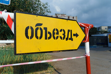 road sign with russian inscription - bypass road, traffic is prohibited and road works, the road is...