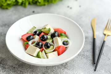 Fresh delicious Greek salad with tomato, cucumber, onions and olives with olive oil