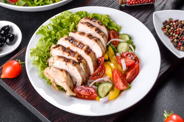Fresh delicious salad with chicken, tomato, cucumber, onions and greens with olive oil