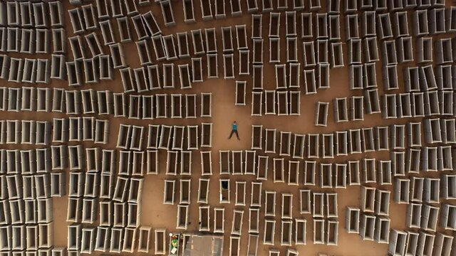 Man in the center of open empty graves, aerial view
drone view pull up shot revealing dozens of open emty tombs 
