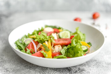 Fresh delicious salad with chicken, tomato, cucumber, onions and greens with olive oil