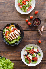 Three fresh delicious salads with chicken, tomato, cucumber, onions and greens with olive oil