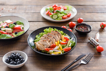 Fresh delicious salad with chicken, tomato, cucumber, onions and greens with olive oil