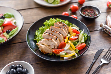 Fresh delicious salad with chicken, tomato, cucumber, onions and greens with olive oil