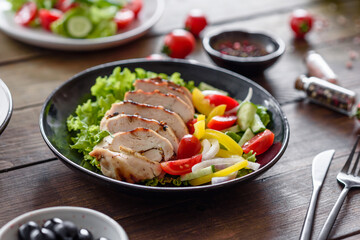 Fresh delicious salad with chicken, tomato, cucumber, onions and greens with olive oil