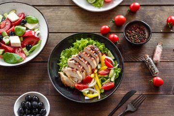 Fresh delicious salad with chicken, tomato, cucumber, onions and greens with olive oil