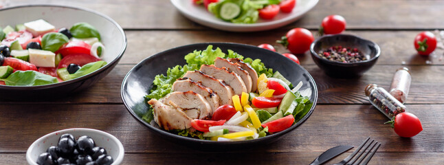 Fototapeta na wymiar Fresh delicious salad with chicken, tomato, cucumber, onions and greens with olive oil