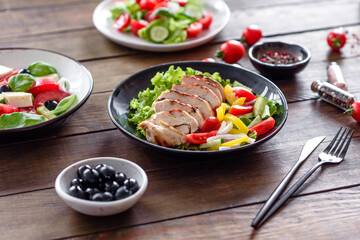 Fresh delicious salad with chicken, tomato, cucumber, onions and greens with olive oil