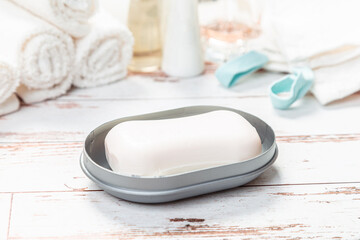 Fototapeta na wymiar soap on a gray plastic soap dish, on a white wooden table.