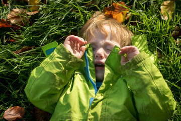High Angle View Of little Boy Crying While Lying Down On Grassy Field