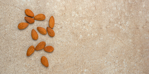 Peeled almonds. Nut background, banner, almonds in top view in a saucer and scattered around. Place...