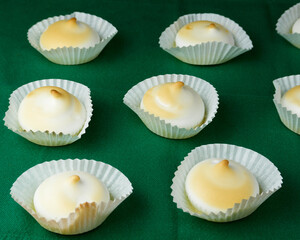 Several and Delicious French dessert Meringues into a silicone form moulds on green tablecloth