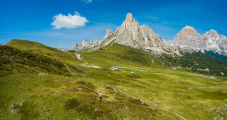Fototapeta premium Aerial view of a man at Giau Pass enjoying Monte Nuvolau mountans. Dolomites, Italy