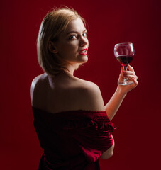 Sensual woman with glass of red wine. Beauty girl with wineglass. Sexy female drinks wine.