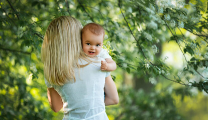 Baby in mom's arms, looking at the camera, behind mom's back