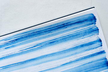 patterned background in cobalt blue watercolor - applied randomly with the flat side of a bristle paint brush on standard sketchbook paper in rows - photo top-down or flat lay style with free s