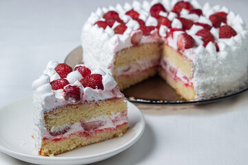 Creamy strawberry cake. Homemade cake with whipped cream and fresh strawberries. Cut piece of cake