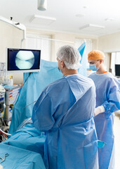 Operating room with surgery in progress. Medical team performing surgical operation in bright modern operating room