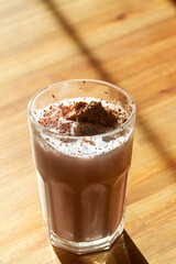 A glass of strawberry milkshake with ice cream