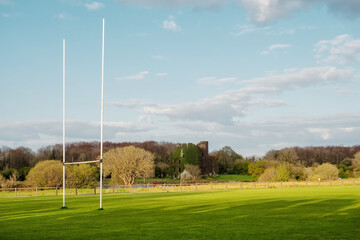 Tall goal posts for Irish national sports, camogie, hurling, Gaelic football, soccer and rugby. Warm sunny day. Blue cloudy sky. Menlo castle in the background. Galway city, Ireland