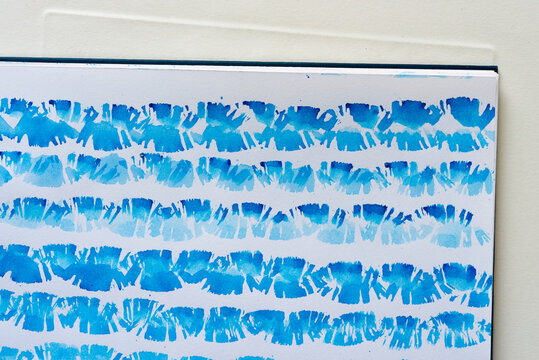cobalt blue watercolour pattern, consisting of dry and wet bristle-tipped brushwork on white sketchbook paper in parallel lines shaped like treads or fans