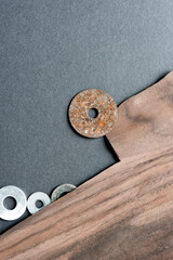 abstract composition with rusty metallic washers, grey mat board, and dark wood veneer - backgrounds