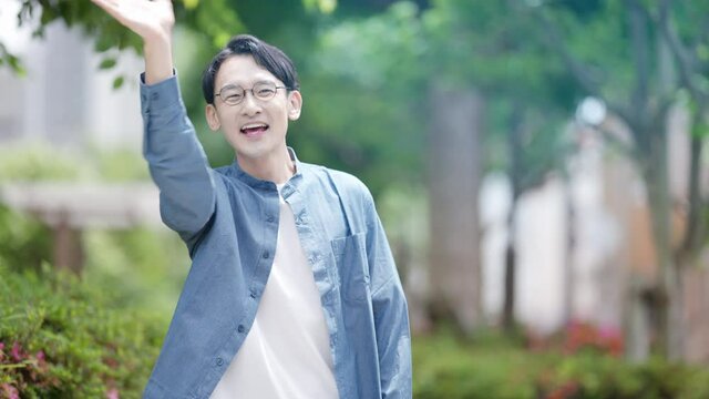 友人と待ち合わせをしている若い男性